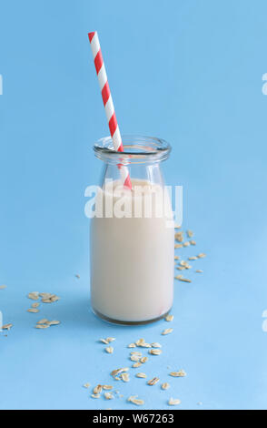 Le lait d'avoine végétalien, non dairy lait de substitution sur un fond bleu clair Banque D'Images