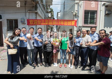 Zhong Fengmin, sa famille américaine et chinoise, les bénévoles et les agents de police de prendre une photo dans la ville de Guangzhou, province du Guangdong en Chine du sud, le 3 juillet Banque D'Images