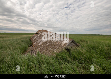 Le toit s'est effondré sur une ferme abandonnée sur la prairie dans le sud de la Saskatchewan. Banque D'Images