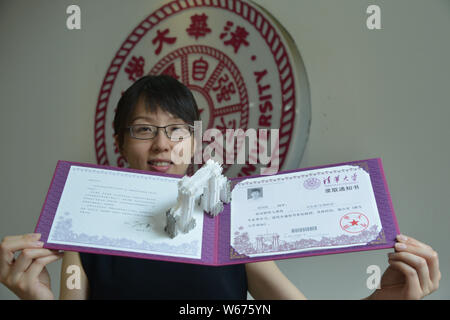 Un enseignant montre la lettre d'acceptation de l'Université de Tsinghua, 2018 avec une sculpture de papier 3D de la deuxième barrière symbolique - la vieille porte" du collège Banque D'Images