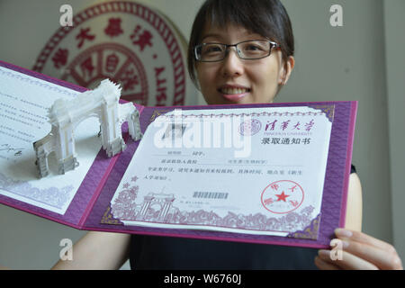 Un enseignant montre la lettre d'acceptation de l'Université de Tsinghua, 2018 avec une sculpture de papier 3D de la deuxième barrière symbolique - la vieille porte" du collège Banque D'Images