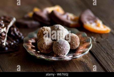 Le chocolat, les truffes et les tranches d'orange dans le chocolat noir sur une table en bois Banque D'Images