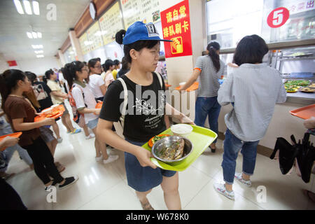 Un étudiant se prépare à profiter gratuitement des plats de poisson, qui sont récoltées à partir de la 210 Daoqian Lake dans le campus de l'Université de médecine de Guangxi, au collège peut Banque D'Images