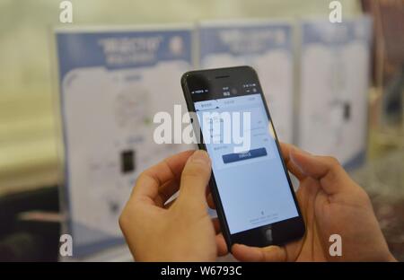 Un utilisateur de téléphone mobile chinois utilise sa carte d'identité électronique dans l'application messagerie Weixin, ou de WeChat, Tencent, sur son smartphone pour vérifier dans Banque D'Images