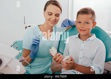 Petit garçon l'éducation sur les soins des dents de son dentiste. Banque D'Images