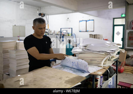 --FILE--fan de l'aviation chinoise Liu Dong, qui tourne son intérêt d'enfance dans une carrière de vie, les chèques des morceaux de papier afin de créer des avions de papier à son wor Banque D'Images