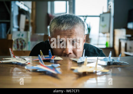 --FILE--fan de l'aviation chinoise Liu Dong, qui tourne son intérêt d'enfance dans une carrière de vie, regarde les avions de papier faite par lui-même dans son atelier Banque D'Images