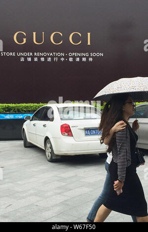 --FILE--piétons passent devant une publicité pour Gucci à Fuzhou City, dans le sud-est de la province de Fujian en Chine, 29 mai 2014. Louis Vuitton a d'abord Banque D'Images