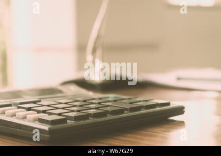 Close up d'une calculatrice sur bureau. Un formulaire de demande de prêt à distance. L'entreprise Financement de concept. Vintage background. Isolées. Copier sp Banque D'Images