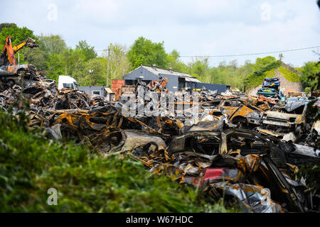 Des tas de voitures brûlées sont pictrured à un parc à ferrailles en Ammanford, Pays de Galles, Royaume-Uni après un incendie, laissant tordus et chard metal partout. Banque D'Images