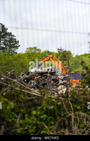 Des tas de voitures brûlées sont pictrured à un parc à ferrailles en Ammanford, Pays de Galles, Royaume-Uni après un incendie, laissant tordus et chard metal partout. Banque D'Images