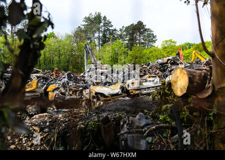 Des tas de voitures brûlées sont pictrured à un parc à ferrailles en Ammanford, Pays de Galles, Royaume-Uni après un incendie, laissant tordus et chard metal partout. Banque D'Images