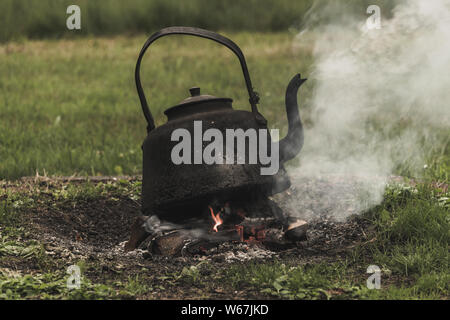 Ancien fer à repasser électrique est chauffé sur un feu de joie. Concept de camping et de plein air. Banque D'Images