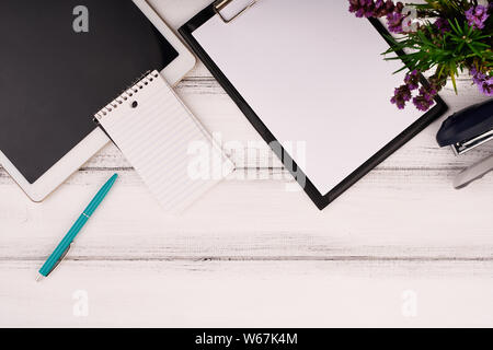 Planner sur la table de travail en bois avec l'ordinateur. Papier blanc vierge sur un bureau de travail Banque D'Images
