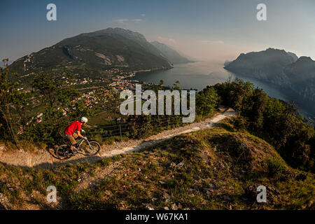 Le lac de Garde, Italie. Un vélo de montagne équitation le long d'une voie unique étroite menant vers la ville de Riva del Garda. Banque D'Images