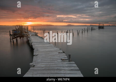 Coucher de soleil paysage de bateaux de pêche artisanale dans l'ancienne jetée en bois. Carrasqueira est une destination touristique pour les visiteurs de la côte d'Alentejo près de L Banque D'Images