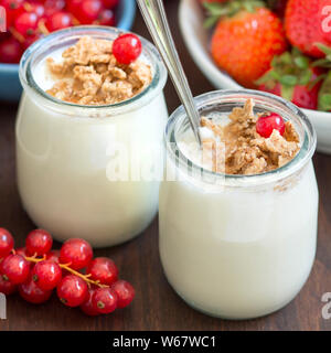 Pots de yaourt naturel frais aux fruits rouges et muesli Banque D'Images