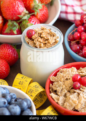 Pot de yaourt frais, petits fruits, muesli et ruban à mesurer Banque D'Images