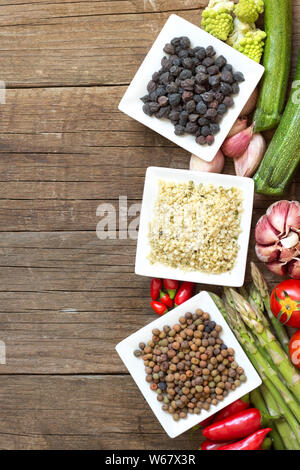 Roveja, graines de chanvre, le pois chiche noir et de légumes sur une table en bois Banque D'Images