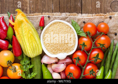 Les matières organiques dans un bol de mil et de légumes sur la table en bois Banque D'Images