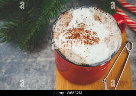 Tasse émaillée rouge Noël avec du chocolat chaud et crème fouettée, des bâtons de cannelle, d'anis étoile et de copieux shortbread cookies sucre brindilles d'épinette, et c Banque D'Images