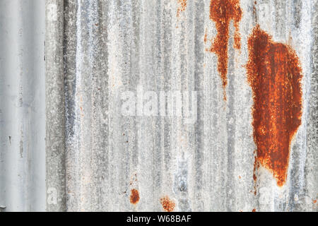 Vieux mur de métal ondulé gris avec des points de rouille, la texture de fond photo frontale Banque D'Images