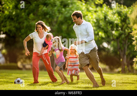 Famille de jouer à un jeu de soccer au parc. Banque D'Images