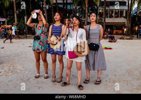 Les touristes se rassemblent pour regarder le coucher du soleil sur la plage Blanche, Boracay, Province d'Aklan, Philippines Banque D'Images