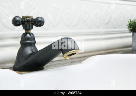 L'eau qui sort du robinet dans l'évier blanc Banque D'Images