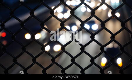 L'autoroute 80W de la Berkeley passerelle pour piétons. Les phares de voitures venant en sens inverse blanc la nuit in soft focus derrière grillage. Banque D'Images
