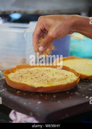 Le processus de fabrication du martabak doux (terang bulan). Le martabak doux commence par une pâte très éggueuse, qui est ensuite versée dans la même grande. Banque D'Images