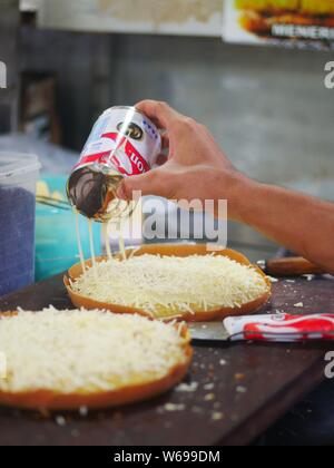 21 juillet 2019 - Tarakan, Indonésie : faire du martabak doux (terang bulan). Le martabak doux commence par une pâte très éggueuse. Banque D'Images