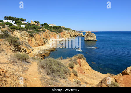 Une vue sur la côte rocheuse à la Praia Do Arrifao Beach donnant sur l'océan Atlantique Banque D'Images