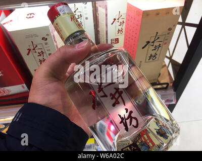 --FILE--un client des magasins pour une bouteille de liqueur Shuijingfang dans un magasin à Shanghai, Chine, 1 décembre 2017. Les producteur de spiritueux Diageo Plc Banque D'Images