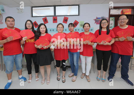 Les enseignants chinois montrent des enveloppes rouges avec 5-yuan billets qui sera donnée à leurs élèves qui seront membres de l'examen d'entrée au collège national annuel Banque D'Images
