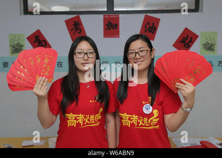 Les enseignants chinois montrent des enveloppes rouges avec 5-yuan billets qui sera donnée à leurs élèves qui seront membres de l'examen d'entrée au collège national annuel Banque D'Images
