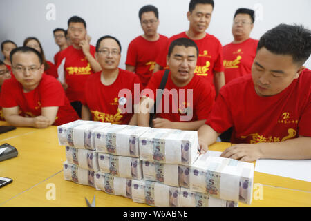 Les enseignants chinois queue pour recevoir 5-yuan billets qui sera donné aux étudiants qui vont se présenter à l'examen d'entrée du collège national annuel, également Banque D'Images