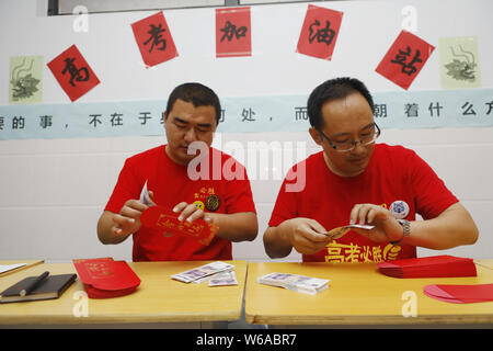 Les enseignants chinois insérez 5-yuan billets dans des enveloppes rouges qui sera donnée à leurs élèves qui seront membres de l'assemblée à l'entrée au collège national ex Banque D'Images