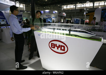 --FILE--visiteurs d'oeil à un modèle train monorail Surnommé 'SkyRail' sur le stand du constructeur automobile électrique BYD pendant l'UrTran / métro à Beijing, 2018 Trans Banque D'Images