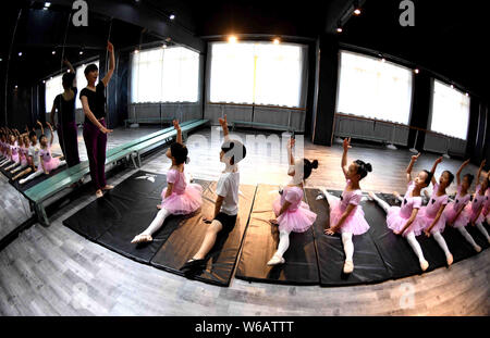 Un enseignant chinois indique à de jeunes filles et un garçon pour se dégourdir les jambes d'apprendre les compétences de danse dans un centre de formation dans la ville de Bozhou, East China's 'anhu Banque D'Images