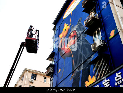 Une femme artiste argentin crée une peinture murale sur le thème de la garde des enfants et les animaux sur un bâtiment résidentiel sur la route Siping à Shanghai, Chine Banque D'Images