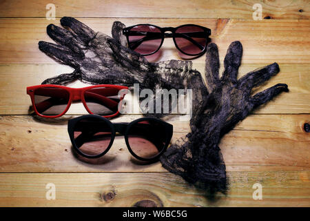 Lunettes et gants sur fond de bois Banque D'Images