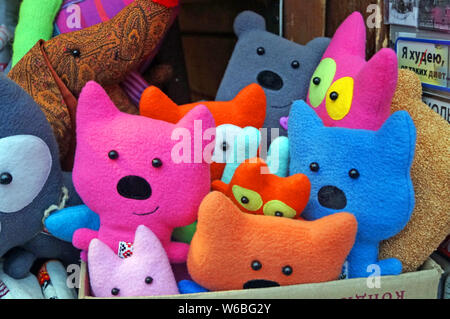 Les jouets en tissu et en céramique de différentes formes et couleurs sont sur le comptoir à la marché de Noël. Banque D'Images