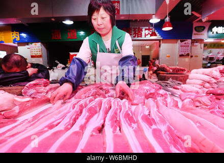 --FILE--Un vendeur vend à un porc de marché libre dans la ville de Nantong, province du Jiangsu en Chine de l'Est, 11 avril 2018. Wang Chang, une ferme porcine manager réduit, Banque D'Images