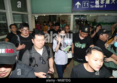 Chanteuse et actrice sud-coréen Bae Susy, mieux connu par les mononym Suzy, au centre, est entouré par des foules de fans au Hong Kong International Air Banque D'Images