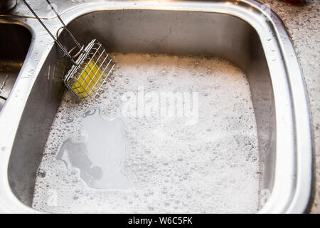 Shaker en usage de savon dans la cuisine. Utilisé pour créer de l'eau savonneuse pour laver la vaisselle dans l'évier. Les gens ont utilisé dans le bon vieux temps avant de savon liquide. L'avenir. Banque D'Images