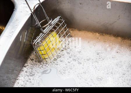 Shaker en usage de savon dans la cuisine. Utilisé pour créer de l'eau savonneuse pour laver la vaisselle dans l'évier. Les gens ont utilisé dans le bon vieux temps avant de savon liquide. L'avenir. Banque D'Images