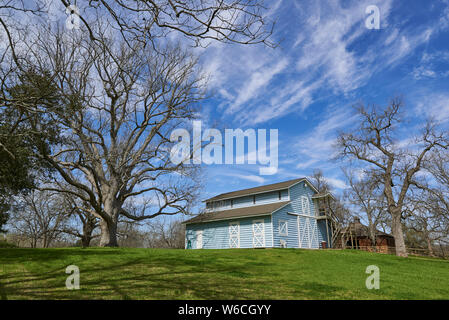 Une pale blue Dutch Barn, entourée d'arbres de noix de pécan sur une propriété près de Richmond, Virginia Banque D'Images