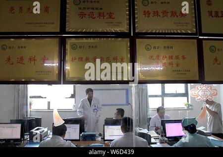 (190801) -- ZHENGZHOU, le 1 août 2019 (Xinhua) -- le Feng Xiuling (2L) communique avec d'autres, à l'office de tourisme le service de chirurgie à l'hôpital des maladies infectieuses du Henan à Zhengzhou, capitale de la province du Henan en Chine centrale, le 31 juillet 2019. Feng Xiuling, 54 ans, est le premier médecin à effectuer des chirurgies pour les malades du SIDA dans le Henan. Depuis 2002, Feng a effectué plus de 3 000 chirurgies pour les malades du SIDA, dans laquelle il a été à risque d'exposition à l'infection à VIH pour quatre fois. "Mon travail est comme marcher sur une lame,' dit-il.Le service de chirurgie Feng travaille pour effectue près de 800 interventions chirurgicales Banque D'Images