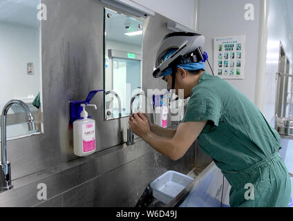 (190801) -- ZHENGZHOU, le 1 août 2019 (Xinhua) -- le Feng Xiuling se lavent les mains avant la chirurgie à l'hôpital des maladies infectieuses du Henan à Zhengzhou, capitale de la province du Henan en Chine centrale, le 31 juillet 2019. Feng Xiuling, 54 ans, est le premier médecin à effectuer des chirurgies pour les malades du SIDA dans le Henan. Depuis 2002, Feng a effectué plus de 3 000 chirurgies pour les malades du SIDA, dans laquelle il a été à risque d'exposition à l'infection à VIH pour quatre fois. "Mon travail est comme marcher sur une lame,' dit-il.Le service de chirurgie Feng travaille pour effectue près de 800 interventions chirurgicales par an, dont les malades du SIDA pour compte Banque D'Images